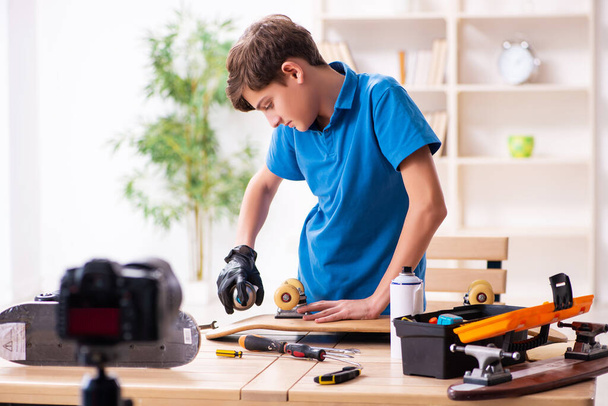 Boy repairing skateboard and recording video for his blog - Photo, Image