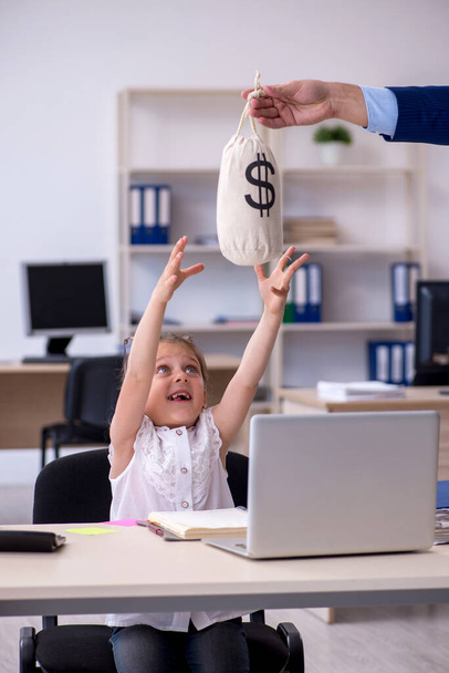 Divertente piccola ragazza che riceve lo stipendio in ufficio - Foto, immagini