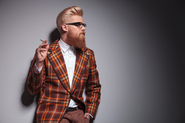 vista lateral de un hombre de moda fresco con gran peinado fumar
 - Foto, Imagen