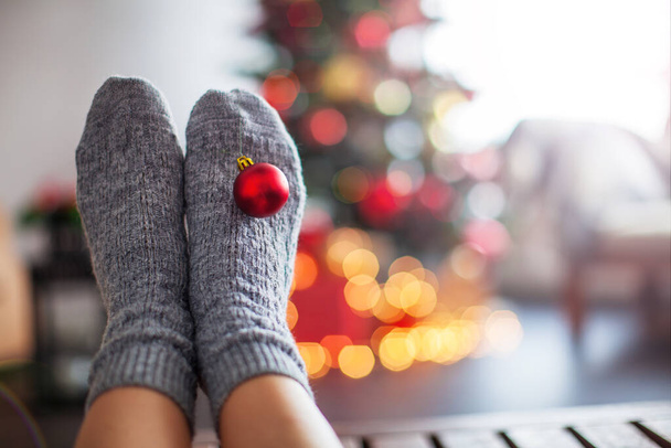 Knitted socks on Christmas tree background - Foto, afbeelding