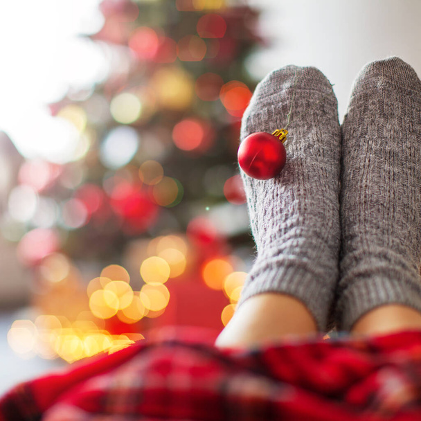 Knitted socks on Christmas tree background - Foto, afbeelding