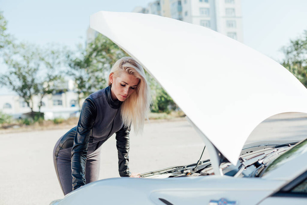Beautiful female blonde mechanic repairs car engine - Fotoğraf, Görsel