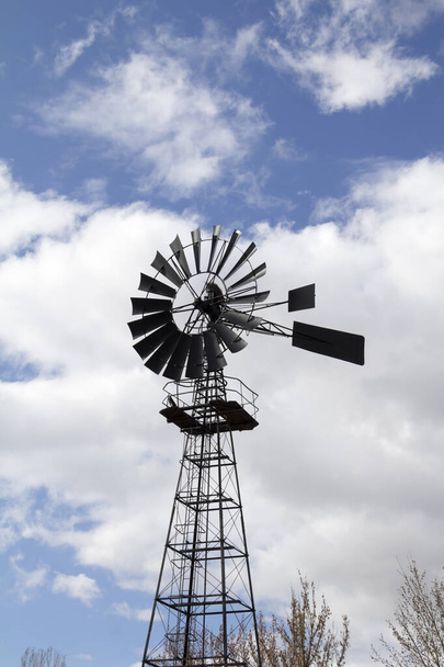 Větrný mlýn proti modré oblačné obloze - Fotografie, Obrázek