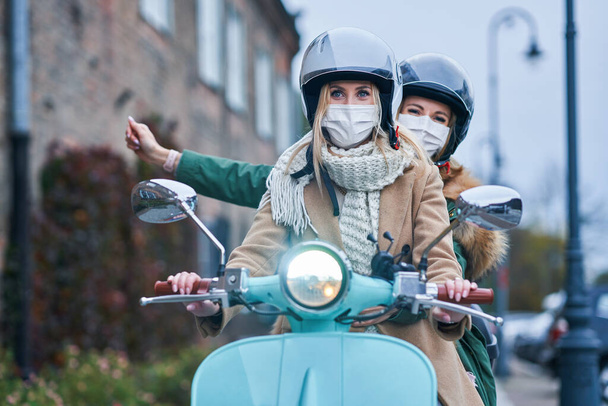 マスクをした2人の女性とスクーターで通勤 - 写真・画像