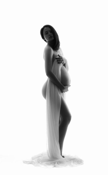 Happy nude Pregnant woman on a light background - Foto, imagen