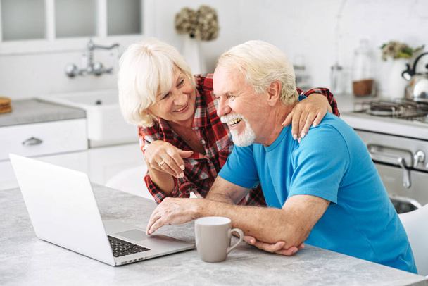 Senior couple with laptop at home - Fotó, kép