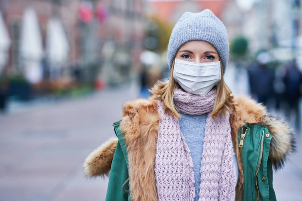 Женщина в маске из-за загрязнения воздуха или эпидемии вируса в городе - Фото, изображение