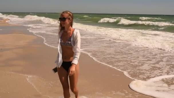  σέξι ευτυχισμένη γυναίκα στηρίζεται στην παραλία τρέχει σε μαγιό μπικίνι με thelephone στο χέρι - Πλάνα, βίντεο