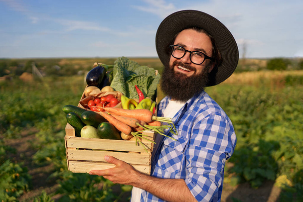 El agricultor sostiene una caja de verduras. Cosecha de otoño. - Foto, Imagen