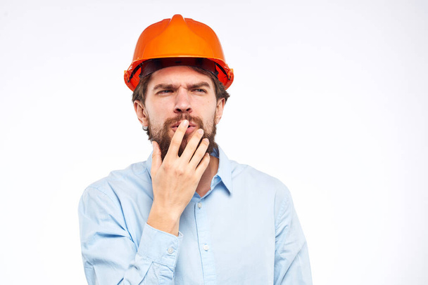 Un uomo in uniforme di lavoro arancione gesti cappello duro con le mani emozioni Ingegnere edile Professionale - Foto, immagini