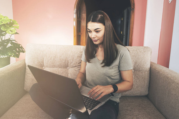 Mujer joven que trabaja usando el ordenador portátil en casa. - Foto, imagen