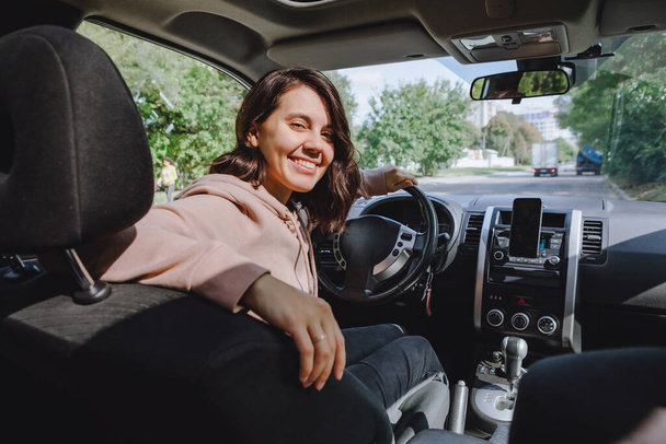 νεαρή όμορφη οδηγός γυναίκα κάθεται στο αυτοκίνητο θέα από το εσωτερικό - Φωτογραφία, εικόνα