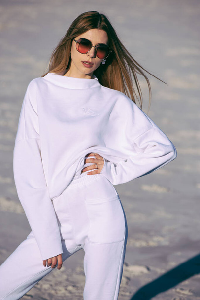 Kobieta moda noszenia białe ciepłe ubrania na zewnątrz na plaży - Zdjęcie, obraz