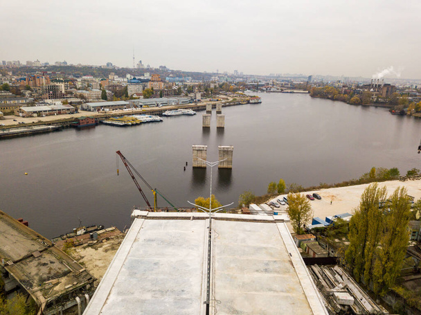 Aerial drone view. The edge of an unfinished bridge in Kiev. Cloudy autumn morning. - Fotó, kép