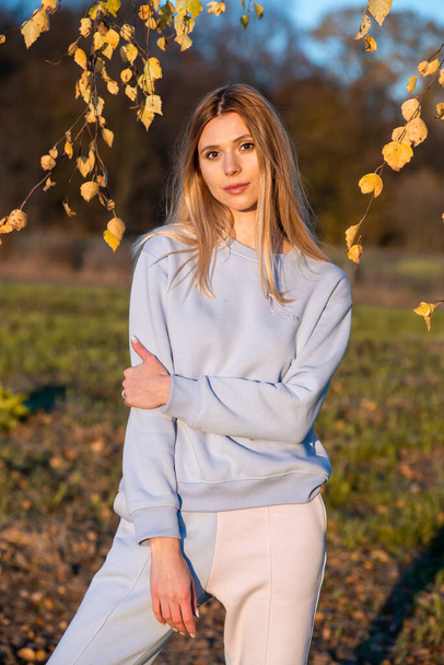 Όμορφη γυναίκα σε λευκό casual ζεστά ρούχα σε ζεστό φθινόπωρο - Φωτογραφία, εικόνα