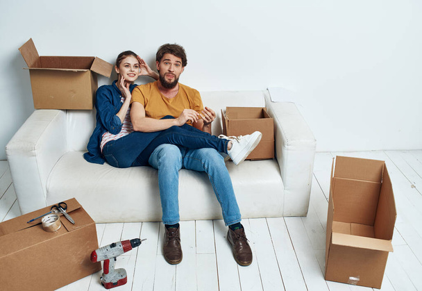 pareja casada en el apartamento en el sofá con cajas de diversión en movimiento - Foto, imagen