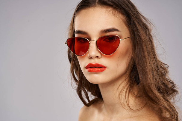Brune à la mode en lunettes de soleil avec modèle de rouge à lèvres de maquillage - Photo, image