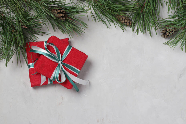 Two Christmas gifts in red paper with green and white ribbons on gray background. Xmas holiday presents. Flat lay. Boxing day. Space for text - Photo, image