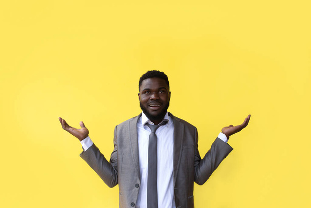 ο Αφρο-Αμερικανός σε κίτρινο φόντο, απλώνει τα χέρια του - Φωτογραφία, εικόνα