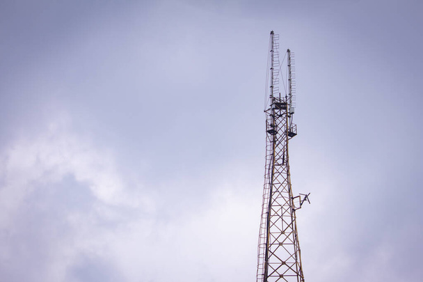 Communication tower with the overcast sky background. - Fotó, kép