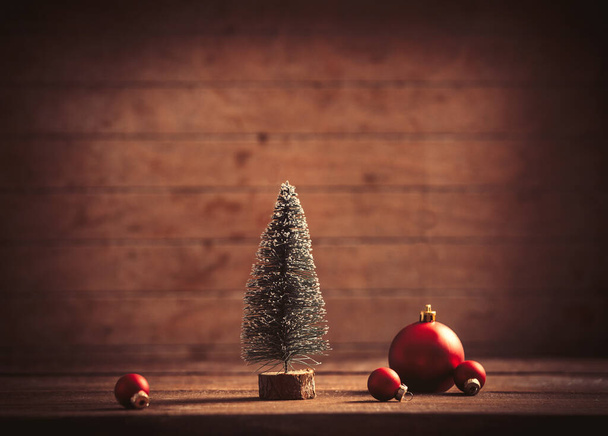 Pequena árvore de Natal e bugigangas na mesa de madeira e fundo - Foto, Imagem
