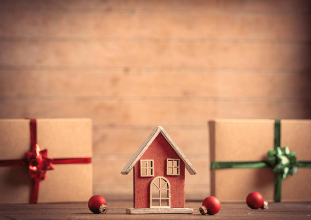 Malý domeček na hraní a vánoční dárky na dřevěném stole  - Fotografie, Obrázek