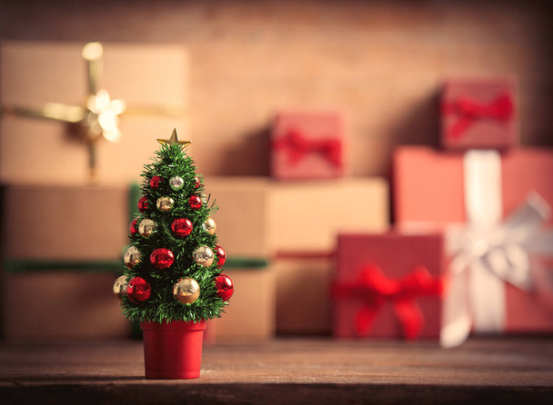 Μικρό χριστουγεννιάτικο δέντρο και κουτιά δώρων στο παρασκήνιο - Φωτογραφία, εικόνα