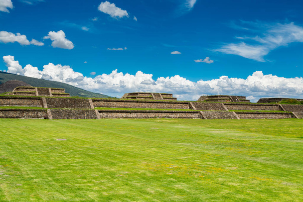Ruiny znaczących architektonicznie mezoamerykańskich piramid i zielonych łąk położonych w Teotihuacan, starożytnym mezoamerykańskim mieście położonym w poddolinie doliny Meksyku - Zdjęcie, obraz