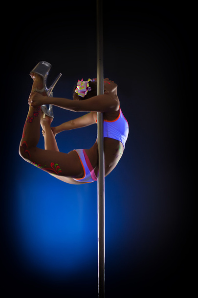 Image of seductive pole dancer posing in jump - Photo, Image