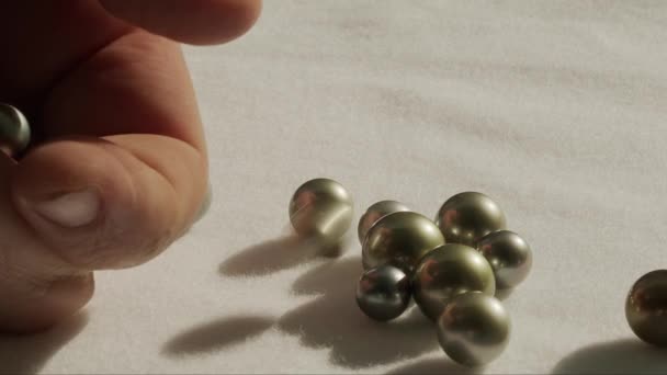 Close up of hand inspecting black Tahitian pearls. - Footage, Video
