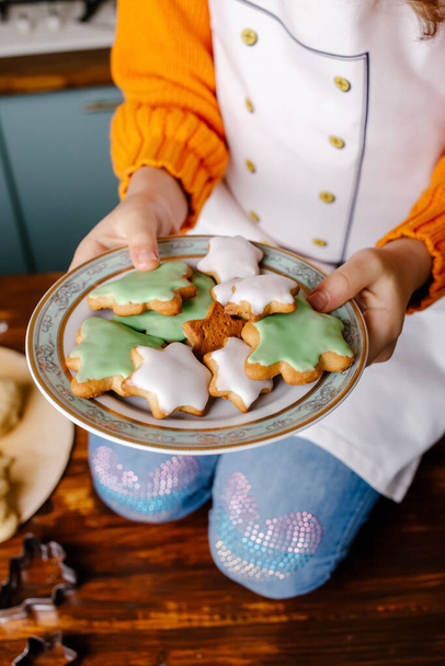 Girl cooked cookies for celebrate Christmas in kitchen at home. Merry Christmas and Happy New Year. Cooking and Holiday concept - Photo, Image