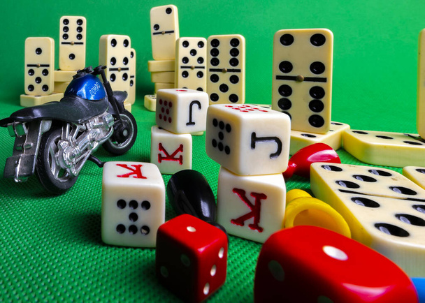 Composition on green background of board games, dice, dominoes, cards and ludo. - Photo, Image