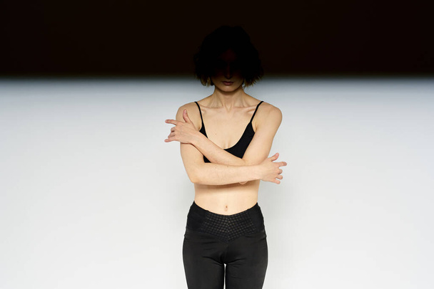 Slender woman in leggings on a light background doing fitness gymnastics exercises - Valokuva, kuva