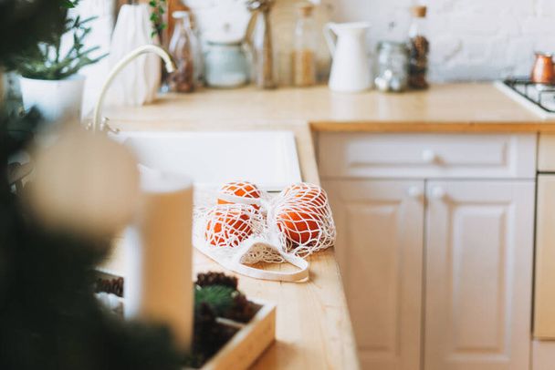 Tangerines dans un sac en tissu à coin cuisine lumineux design scandinave rustique, mur de briques blanches, concept écologique, zéro déchet - Photo, image