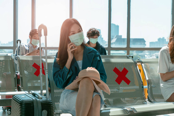 Donna asiatica che utilizza il telefono cellulare in aeroporto seduto vicino alla finestra. - Foto, immagini
