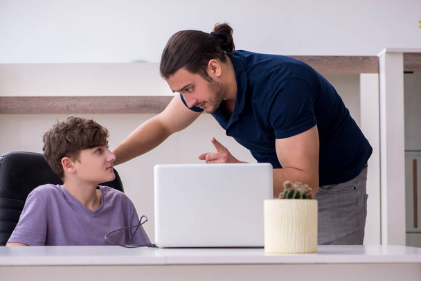 Молодий батько і школяр грають в комп'ютерні ігри вдома
 - Фото, зображення