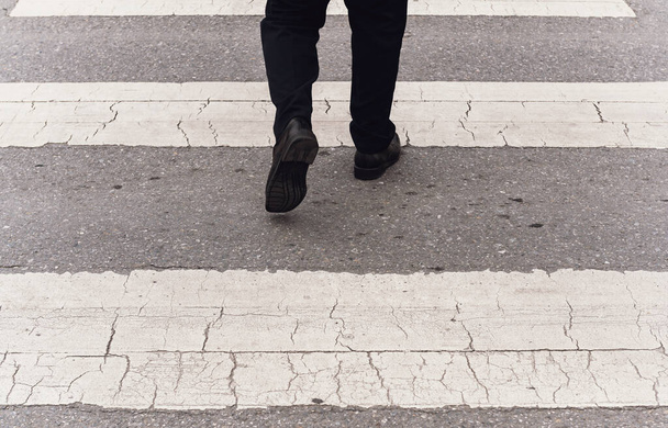 Back view of businessman crossing the street on crosswalk - Фото, изображение