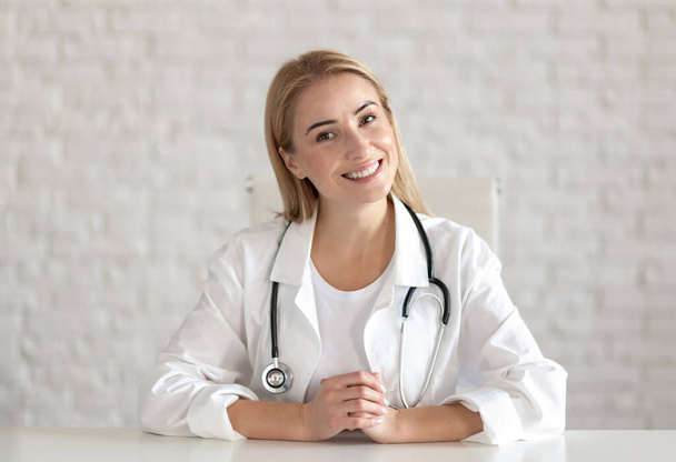 Portrait of a young doctor against the background of the wall. Online consultation concept - Photo, Image