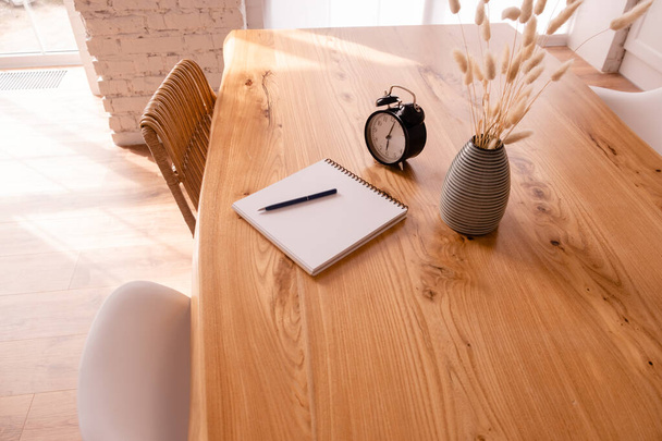 Черный будильник, блокнот и стационарный стол на деревянном столе. Дидлайн и концепция образования. Пространство для копирования верхнего взгляда - Фото, изображение