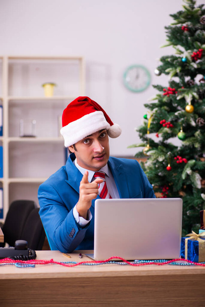 Joven empleado masculino celebrando la Navidad en el lugar de trabajo - Foto, imagen