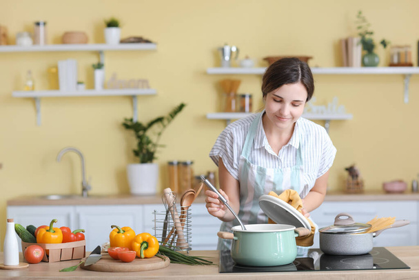 Woman cooking dinner in kitchen - Foto, imagen