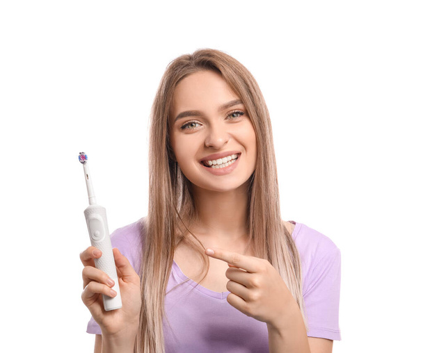 白い背景に電動歯ブラシ付きの若い女性 - 写真・画像