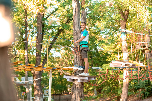 Teenage boy climbing in adventure park - Photo, Image