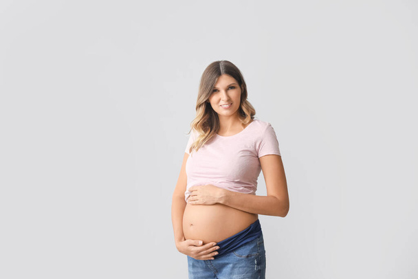 Hermosa mujer embarazada sobre fondo claro - Foto, imagen