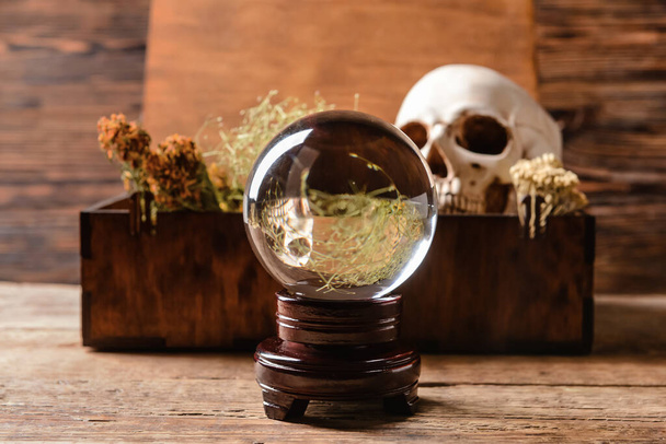 Crystal ball of fortune teller and box with ingredients for vial on wooden table - Photo, Image
