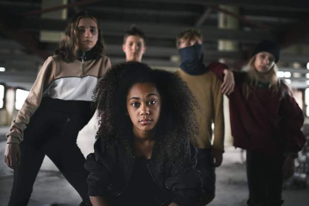 Group of teenagers gang standing indoors in abandoned building, bullying concept. - Photo, image