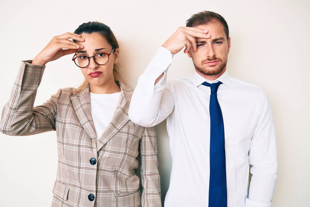 Beautiful couple wearing business clothes worried and stressed about a problem with hand on forehead, nervous and anxious for crisis  - Photo, Image