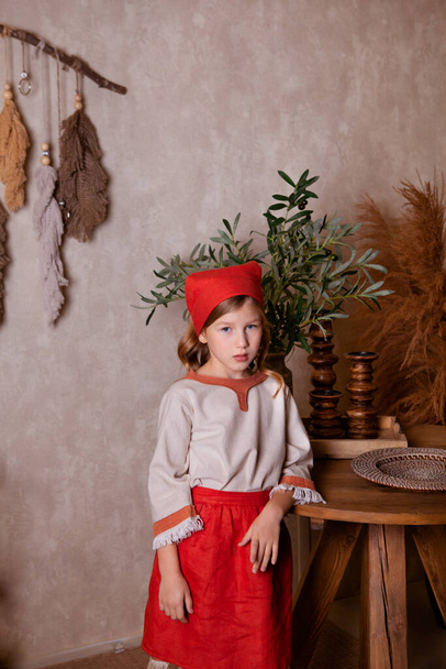 κορίτσι σε ένα ελαφρύ λινό πουκάμισο και ένα κόκκινο μαντήλι σε ρουστίκ στυλ - Φωτογραφία, εικόνα