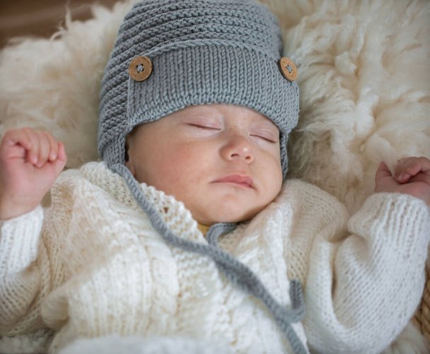 Portrait d'un bébé endormi dans un chapeau tricoté chaud en gros plan. Sommeil bébé. - Photo, image