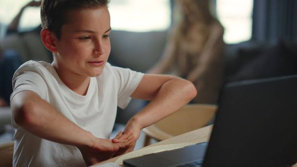Miúdo a ter aulas online em casa. Rapaz bonito usando computador para educação à distância. - Foto, Imagem